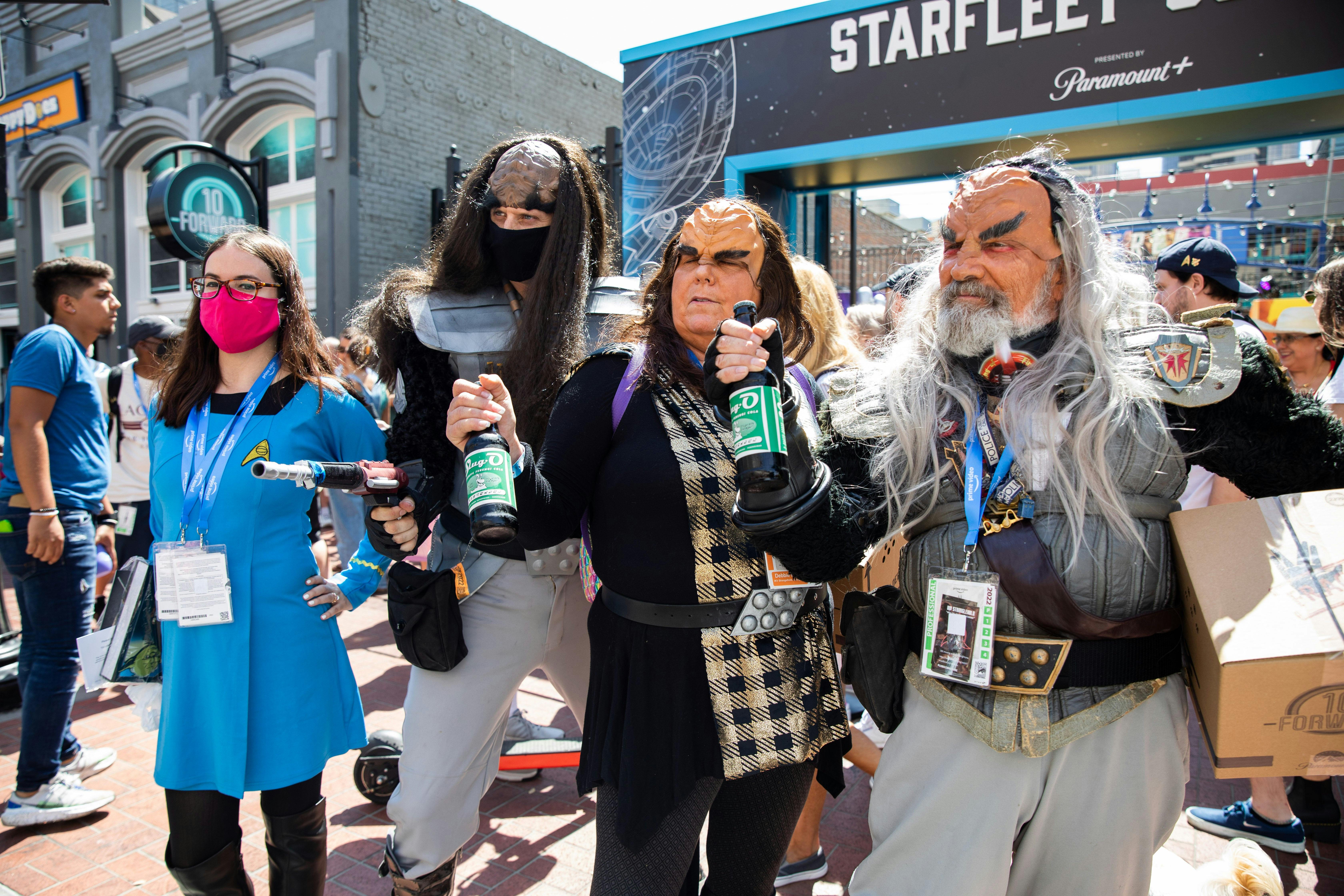 A Starfleet officer and several Klingons pose for a photo.