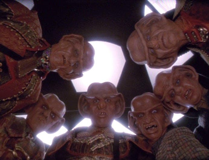 Six Ferengi look directly at the camera.