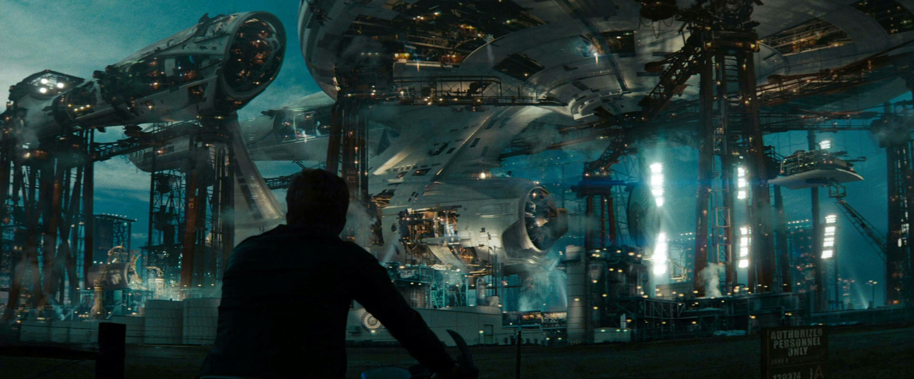 Kirk, arriving on his motorcycle, watches as the Enterprise is constructed in Star Trek (2009)