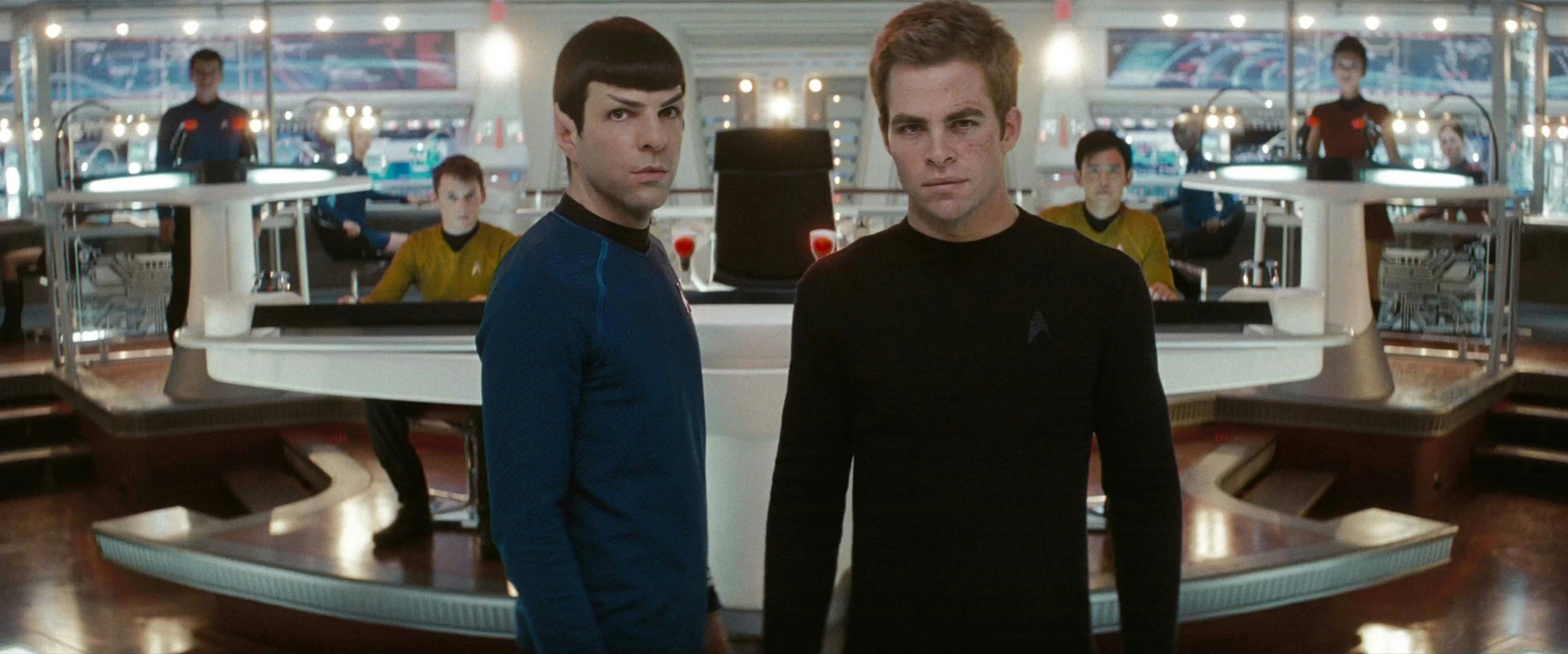 Spock and James Kirk on the Bridge of the Enterprise standing, both looking forward at the viewscreen at Nero, as their crew stands behind them at their stations in Star Trek (2009)