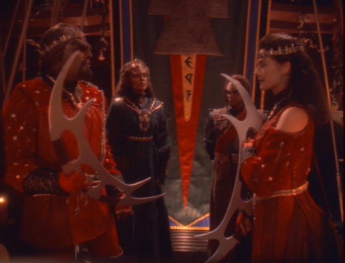 Alexander stands present at his father Worf's wedding to Jadzia Dax as the groom and bride hold their bat'leths in 'You Are Cordially Invited...'