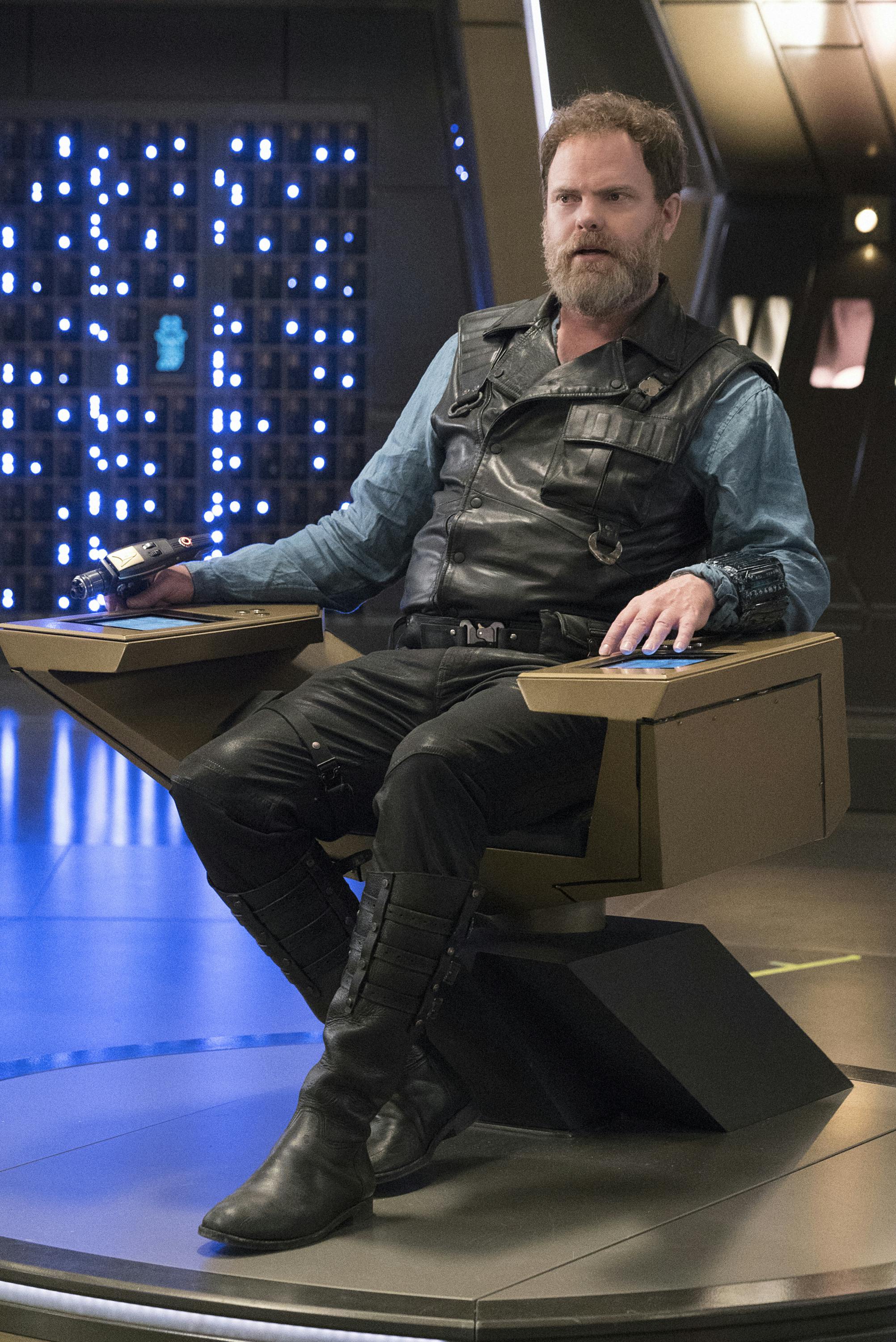 Harry Mudd sits in the Discovery captain's chair holding his phaser after seizing control in 'Magic to Make the Sanest Man Go Mad'