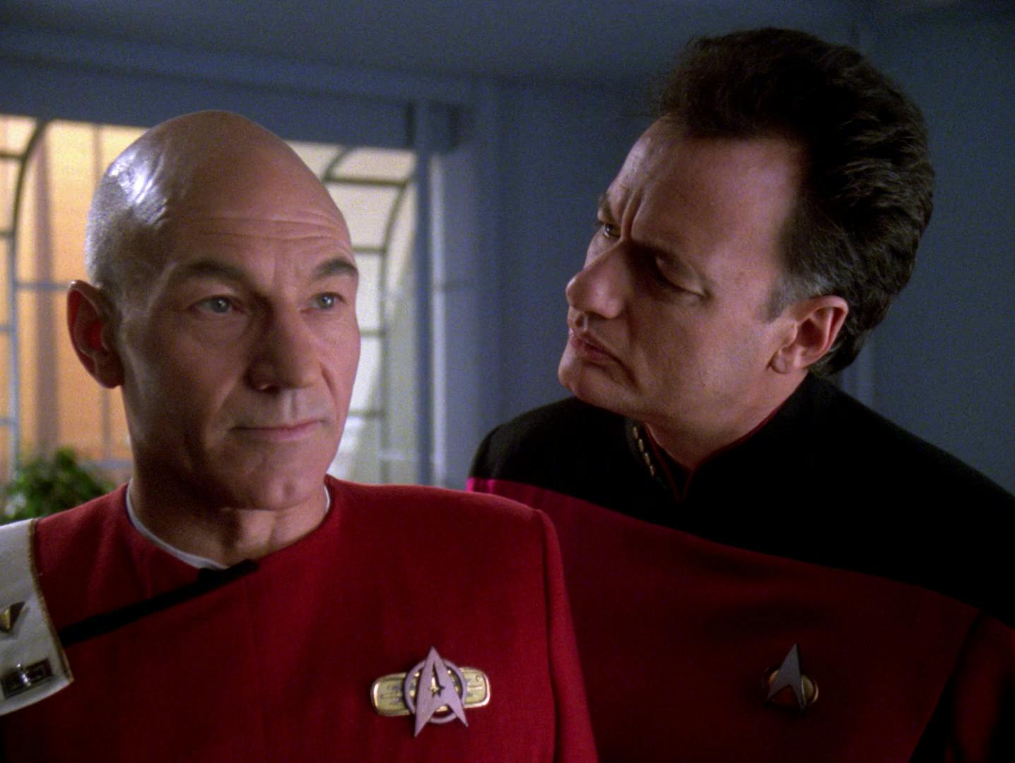 Q looks over Picard's shoulder as he's in his cadet uniform in his old Academy quarters in 'Tapestry'