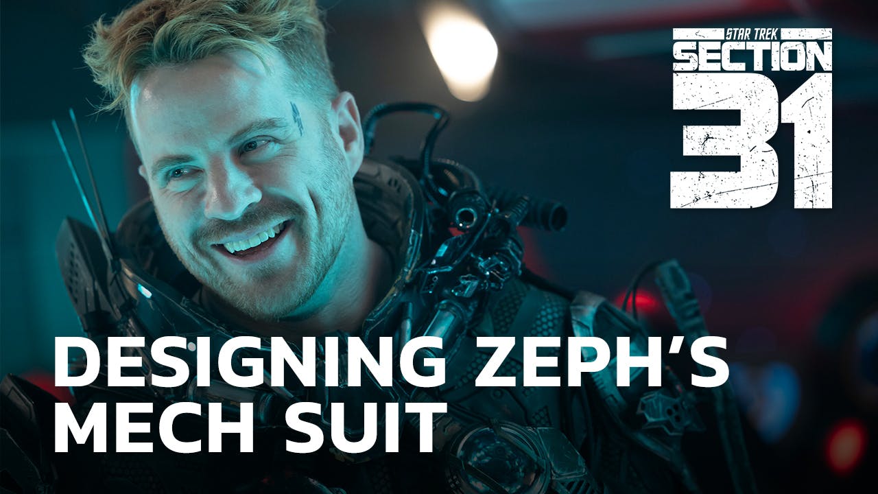 Close-up of a smiling Zeph with the Section 31 logo and the text 'Designing Zeph's Mech Suit'