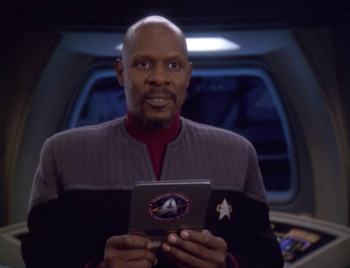 Captain Sisko holds a PADD in his hand aboard the Defiant in 'The Dogs of War'