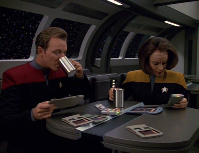 Tom Paris and B'Elanna Torres sit inthe mess hall together as they review their PADDs in 'Threshold'