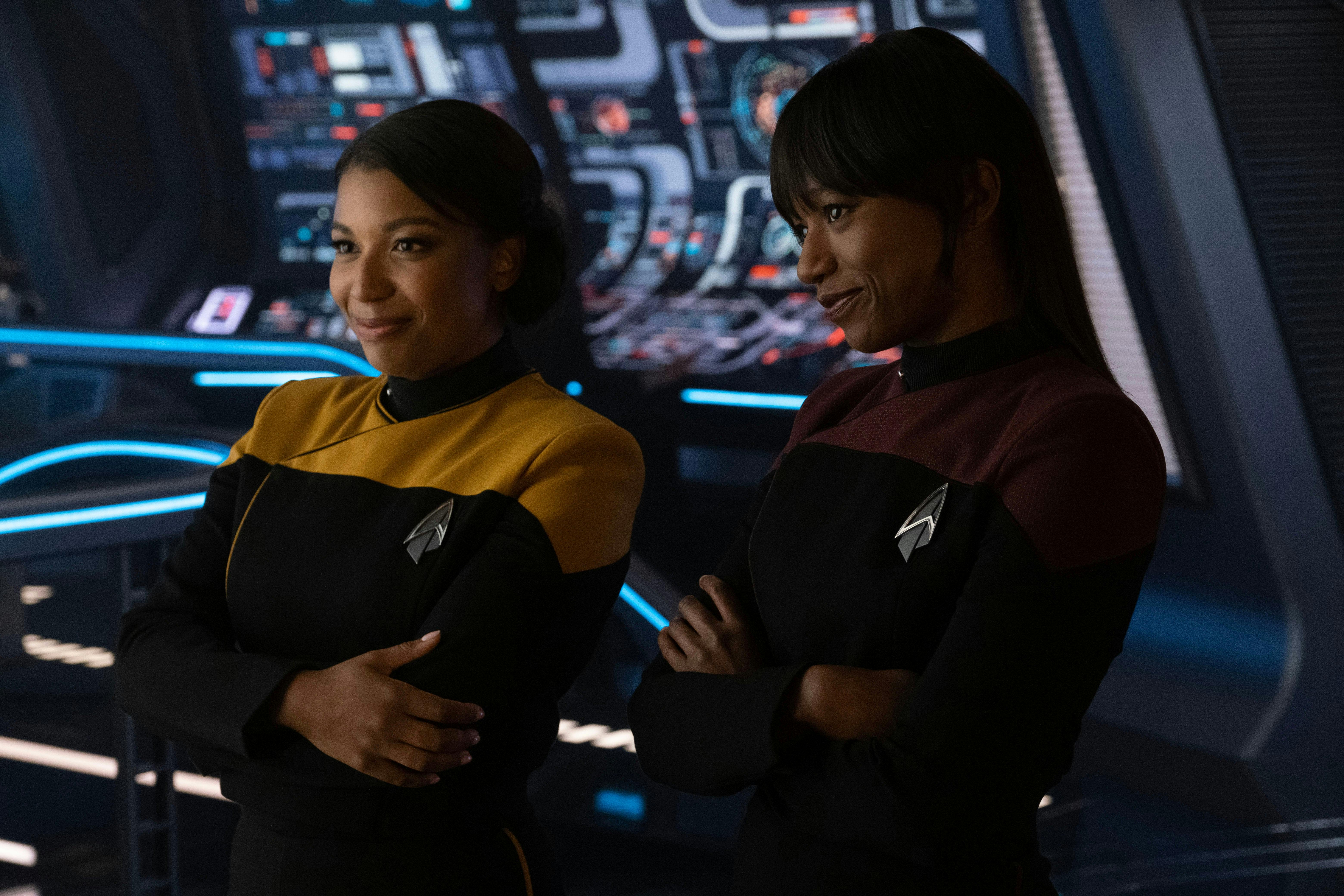 The La Forge sisters, Ensign Alandra and Ensign Sidney, stand side-by-side on the bridge of the Titan