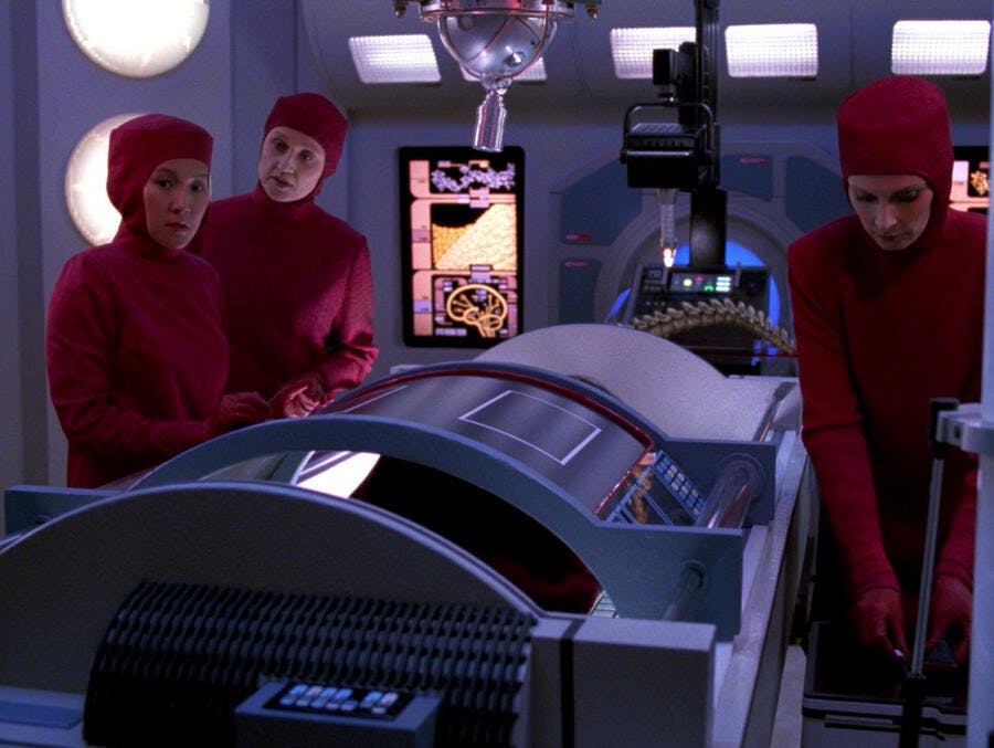 Nurse Alyssa Ogawa, Dr. Toby Russell, and Dr. Beverly Crusher perform an experimental surgery on Worf in 'Ethics'