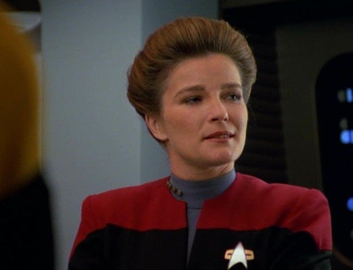 Kathryn Janeway smirks as she gazes over her shoulder in 'Eye of the Needle'