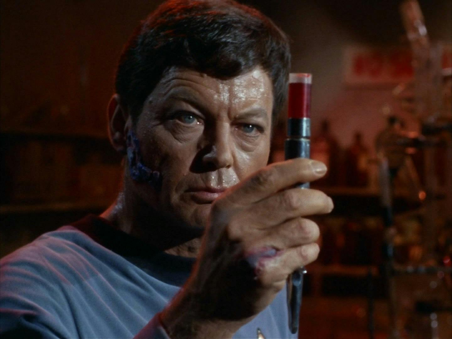 Close-up as McCoy lifts a vial of a synthesized vaccine he was working on in 'Miri'