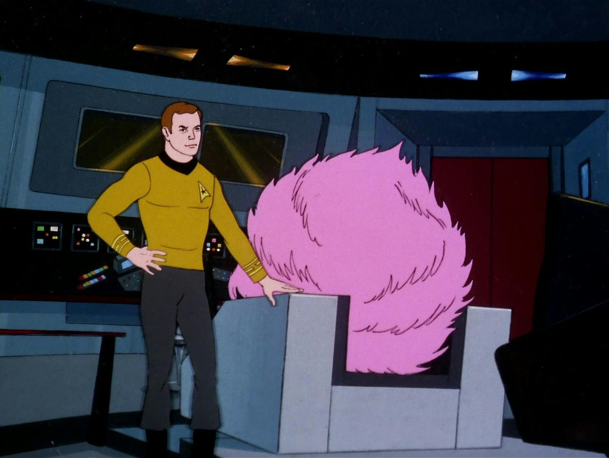 Captain Kirk stands next to a giant tribble perched in the captain&apos;s c...