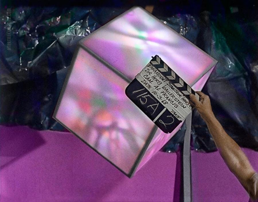 A clapboard for the production of 'That Which Survives' is placed in front of a glowing cube
