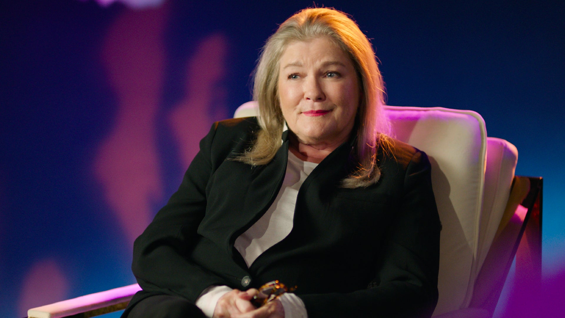 Star Trek: Prodigy's Kate Mulgrew leans back in her chair, looking off camera with a slight smile