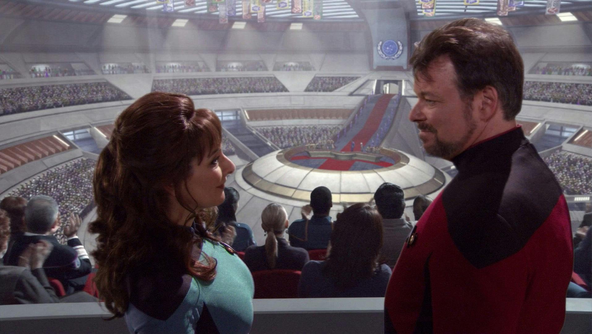 Commander Troi and Commander Riker smile at each other at the founding of the Federation in 'These Are the Voyages...'
