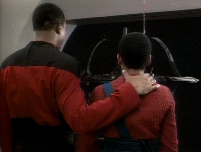 Captain Sisko and Jake look at Deep Space Nine as they approach the station. Their backs are to the camera, and Sisko's arm is around Jake.