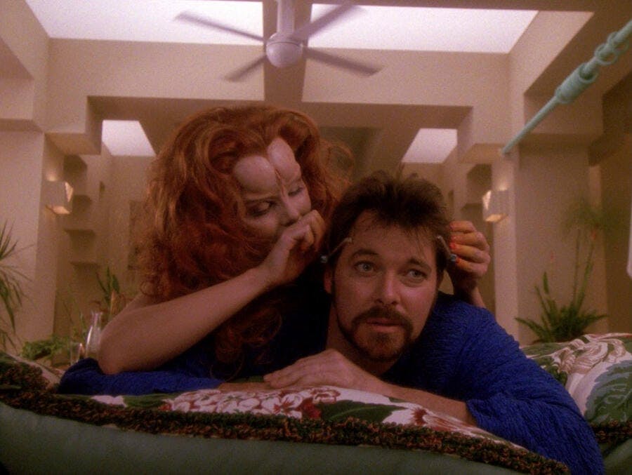 Etana places a game on Riker's head while their in bed in 'The Game' 