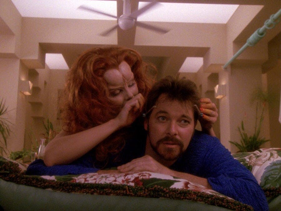 Etana places a game on Riker's head while their in bed in 'The Game'