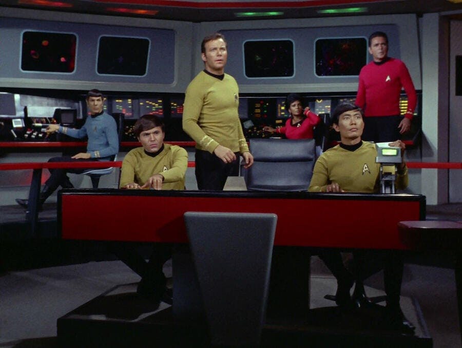 Spock Chekov, Kirk, and Sulu on the Bridge of the Enterprise all with their attention ahead of them in 'Spock's Brain'