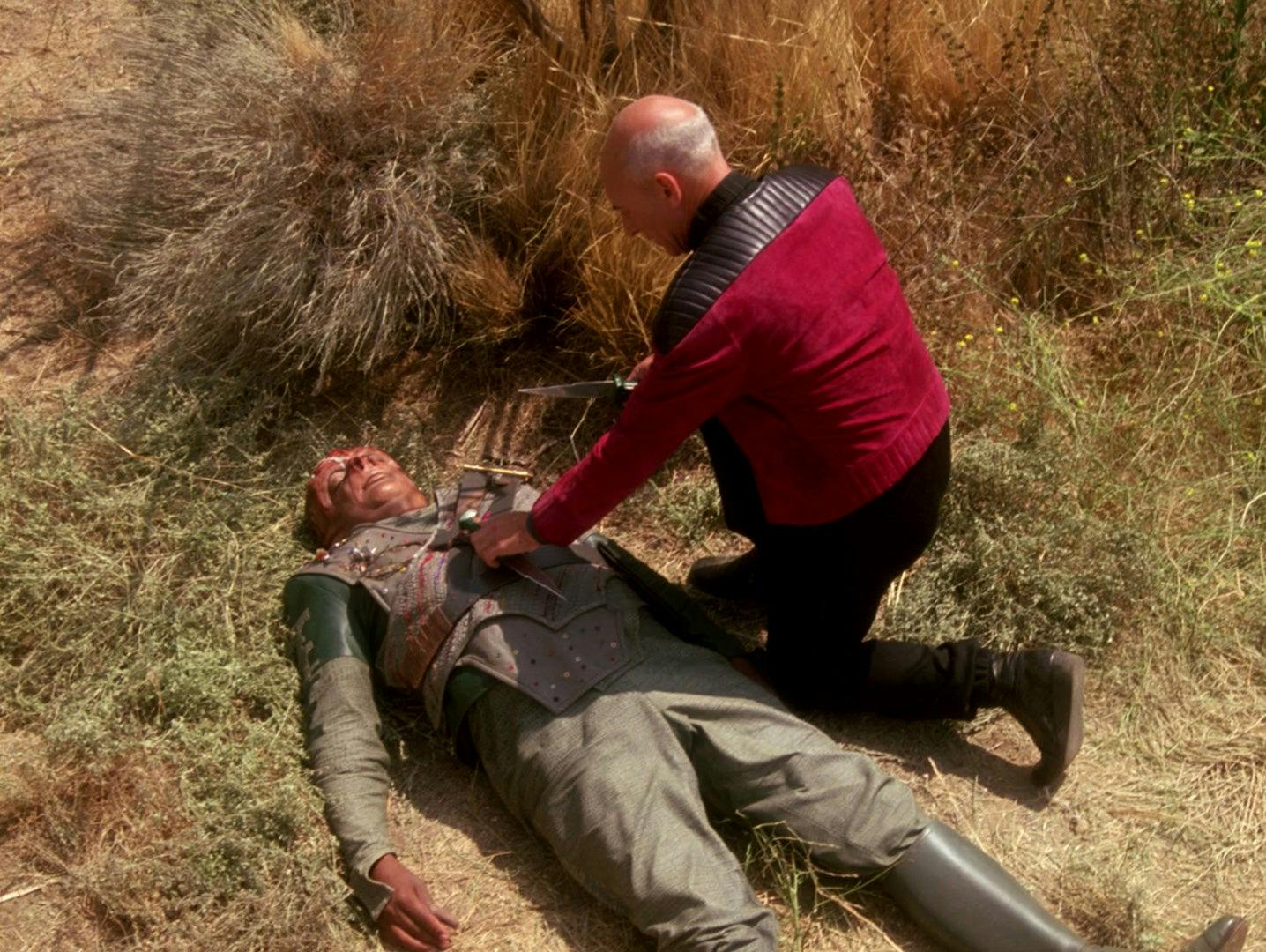 Dathon is mortally wounded, laying on the ground. Picard kneels next to him checking his vitals in 'Darmok'