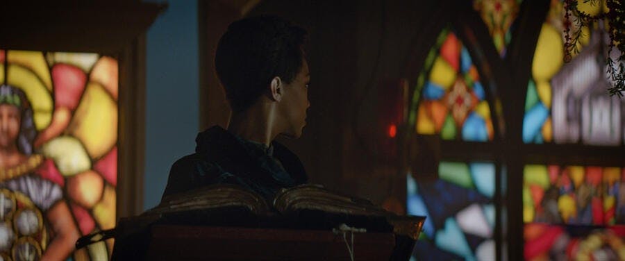 At the pew, Michael Burnham looks over her shoulder at the church's stained glass windows in 'New Eden'