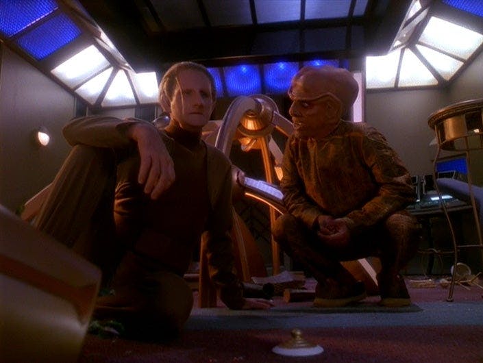 Quark squats next to a deflated and unkempt Odo and offers him friendly advice after he wrecked his room on Star Trek: Deep Space Nine