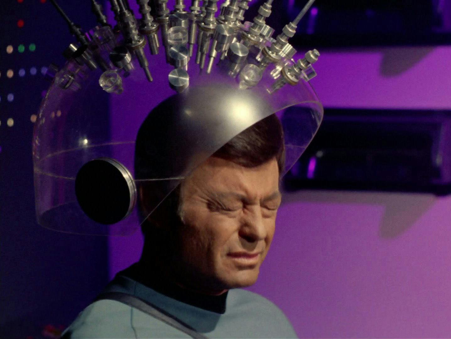 With a helmet contraption on his head, McCoy painfully grimaces in 'Spock's Brain'