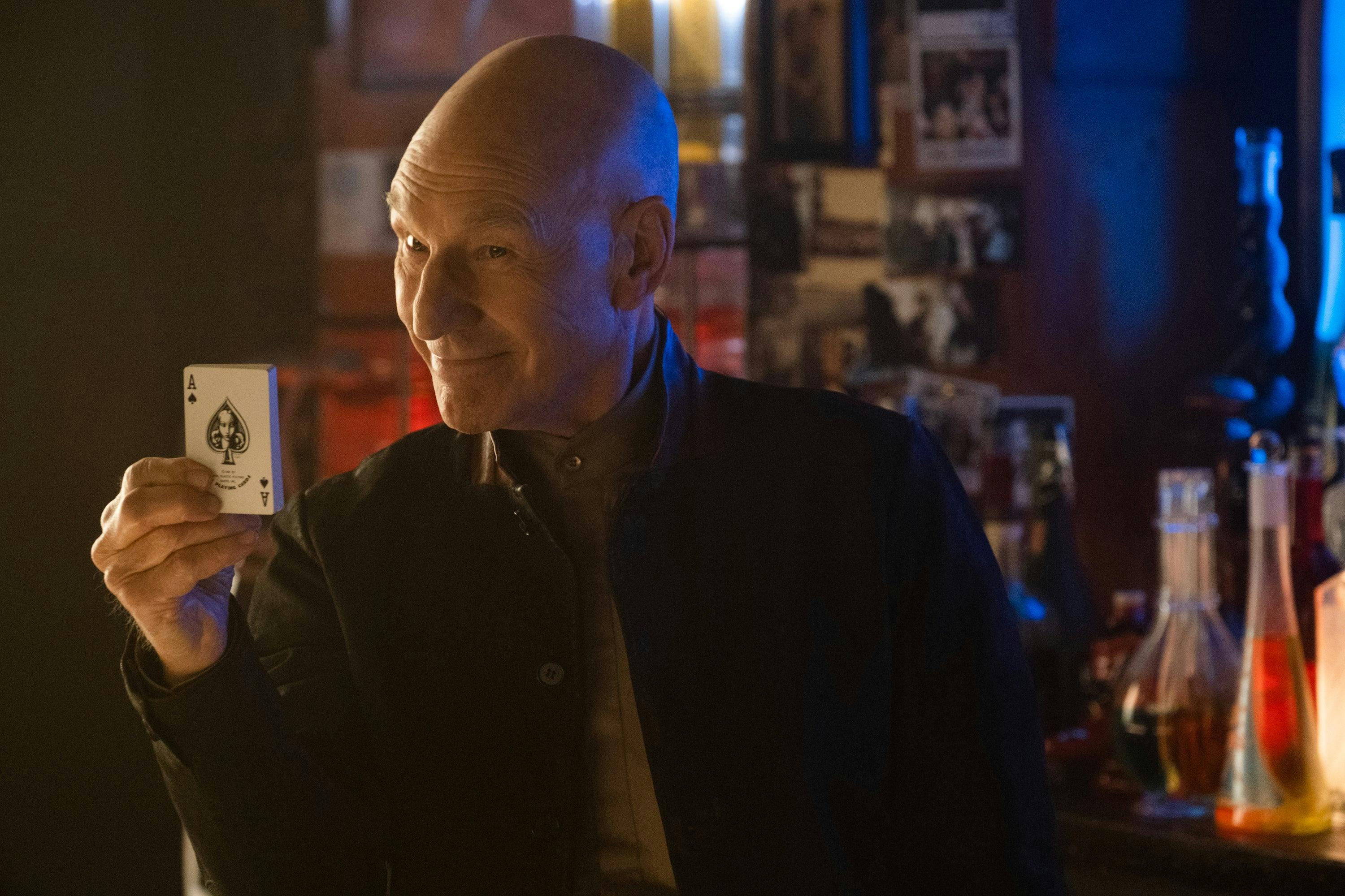 At the 10 Forward holo-program, Picard smiles behind the bar as he holds up a pack of playing cards in 'The Last Generation'