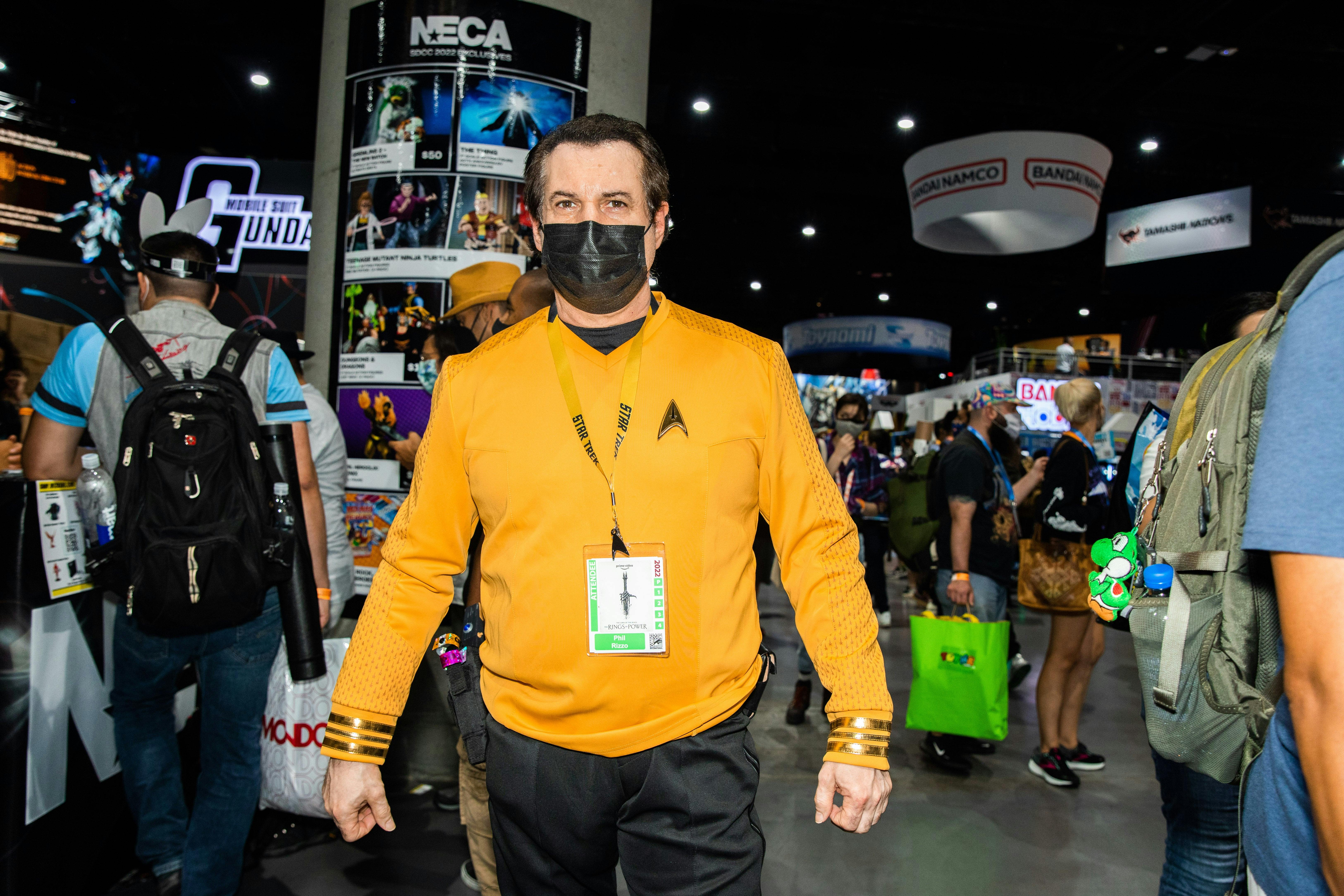 A cosplayer in a gold TOS uniform poses at SDCC.