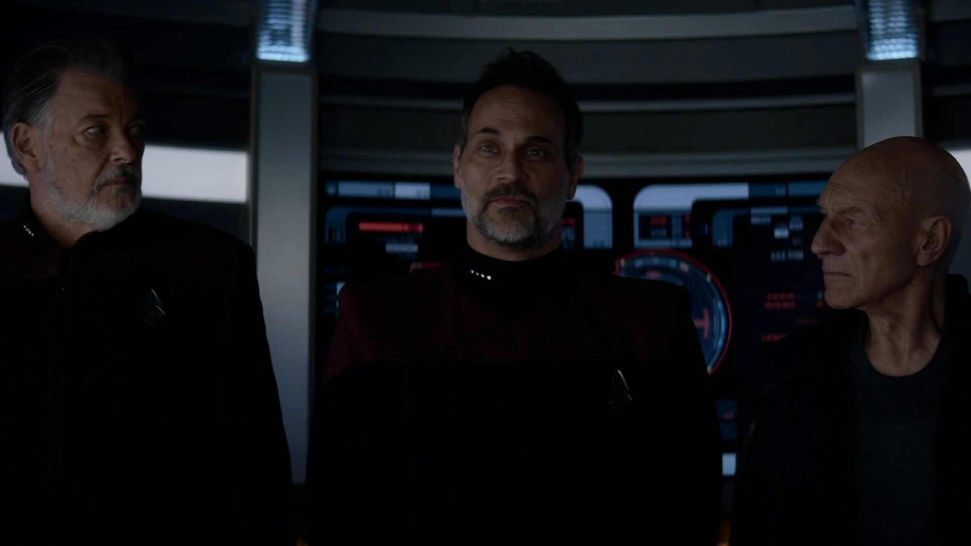 Riker and Picard both turn to face a gleefully smug Captain Shaw in the turbolift in 'Imposters'