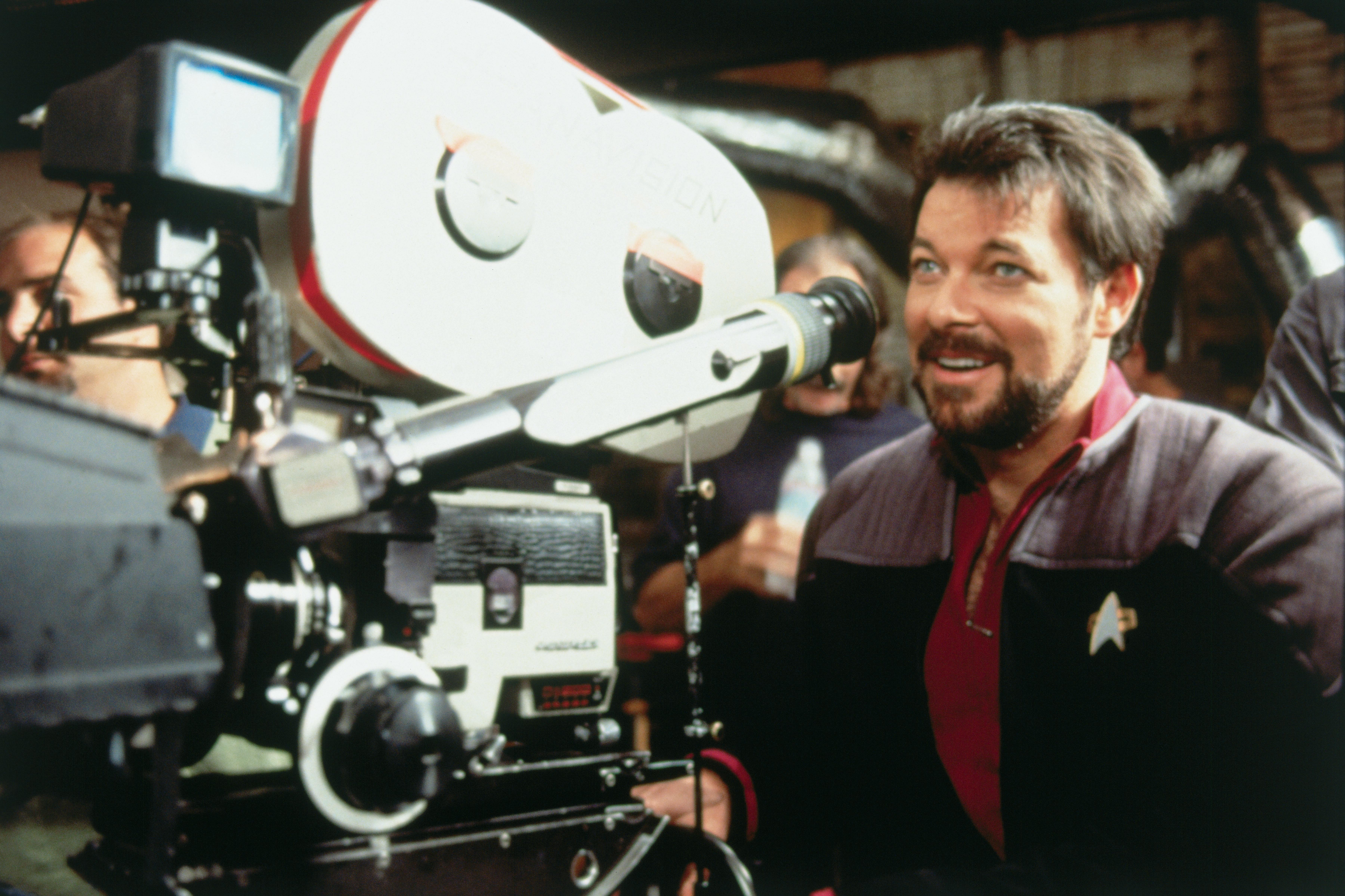 Jonathan Frakes behind the camera in Starfleet uniform smiling, filming First Contact