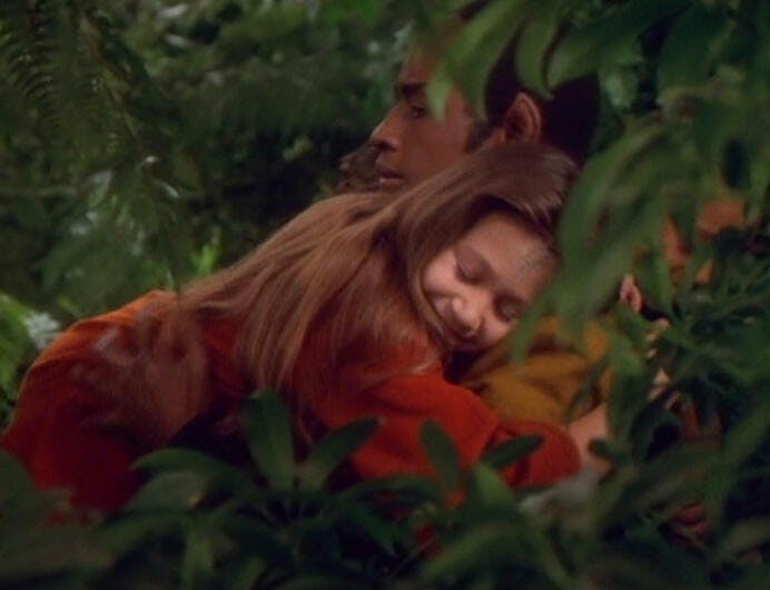 A young child embraces Tuvok with a hug in the woods in 'Innocence'