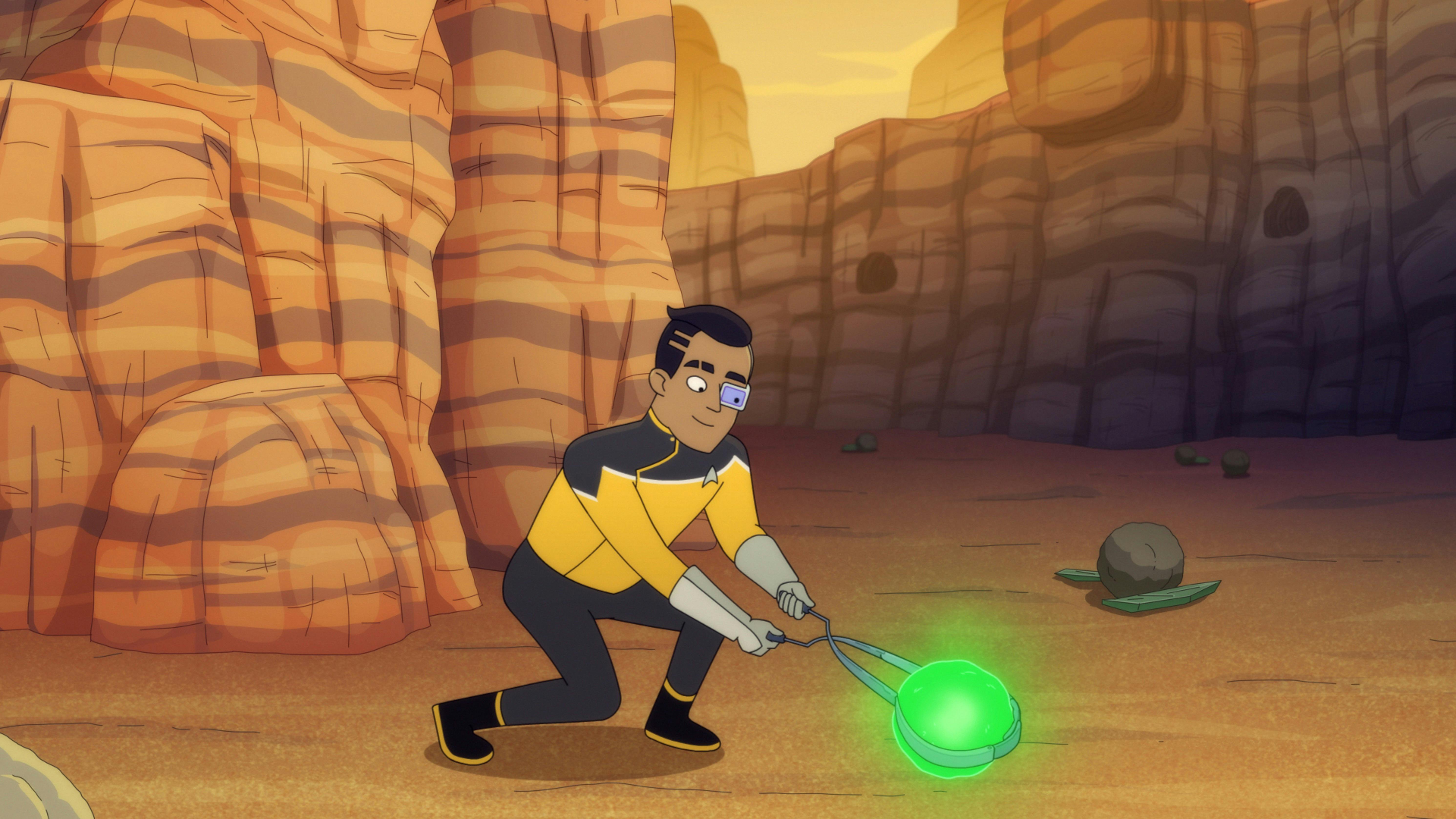 Rutherford, wearing gloves, uses tongs to pick up a glowing green orb.