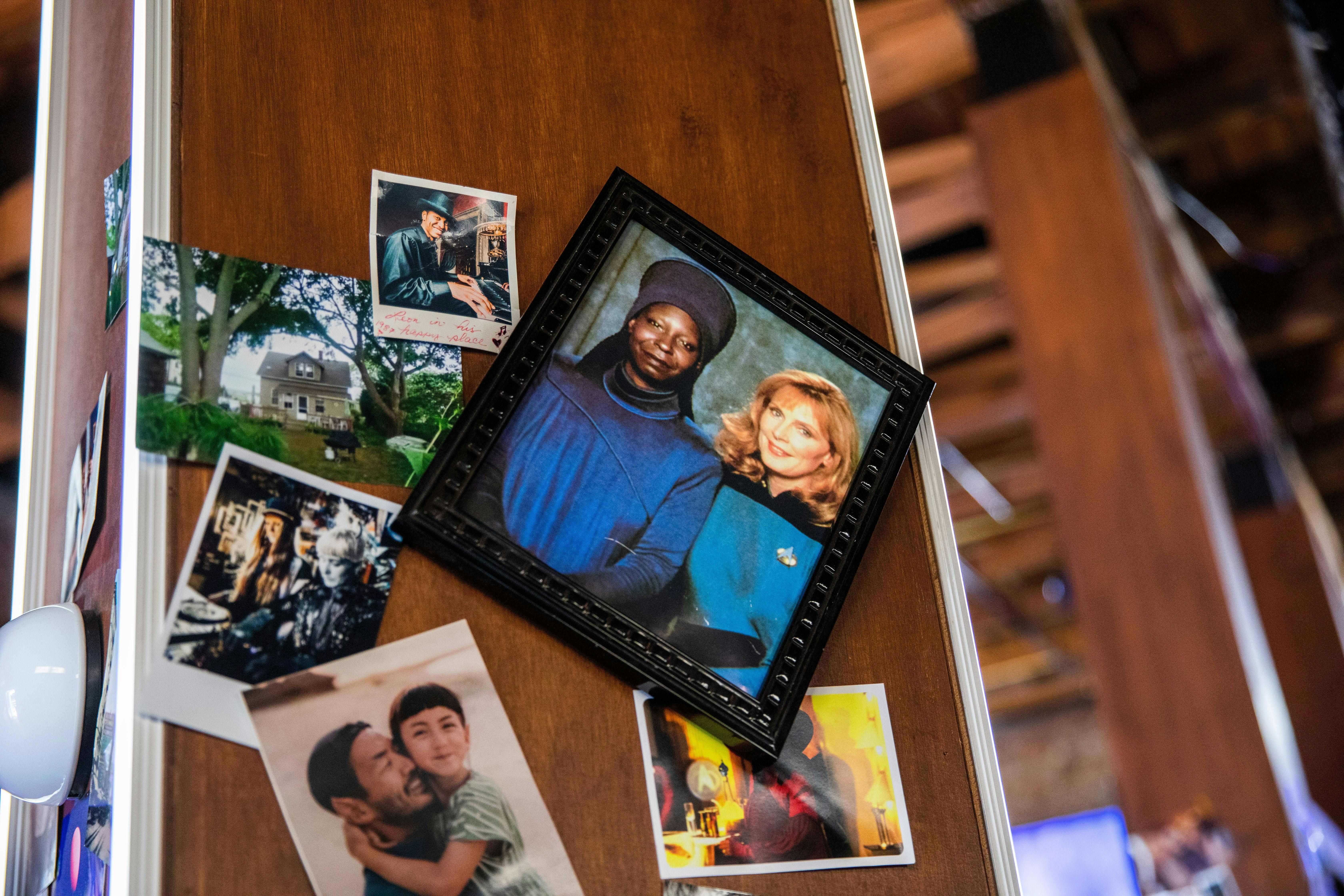Photos decorate the walls of 10-Forward, including a picture of Guinan and Dr. Crusher.