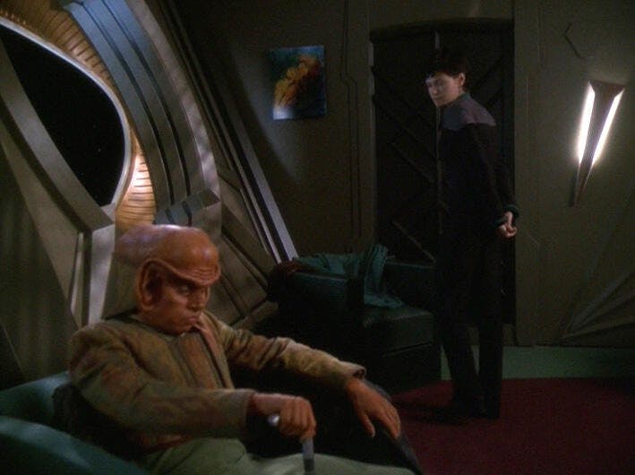 Ezri Dax looks over at a dejected and sullen Nog in his room in 'It's Only A Paper Moon'