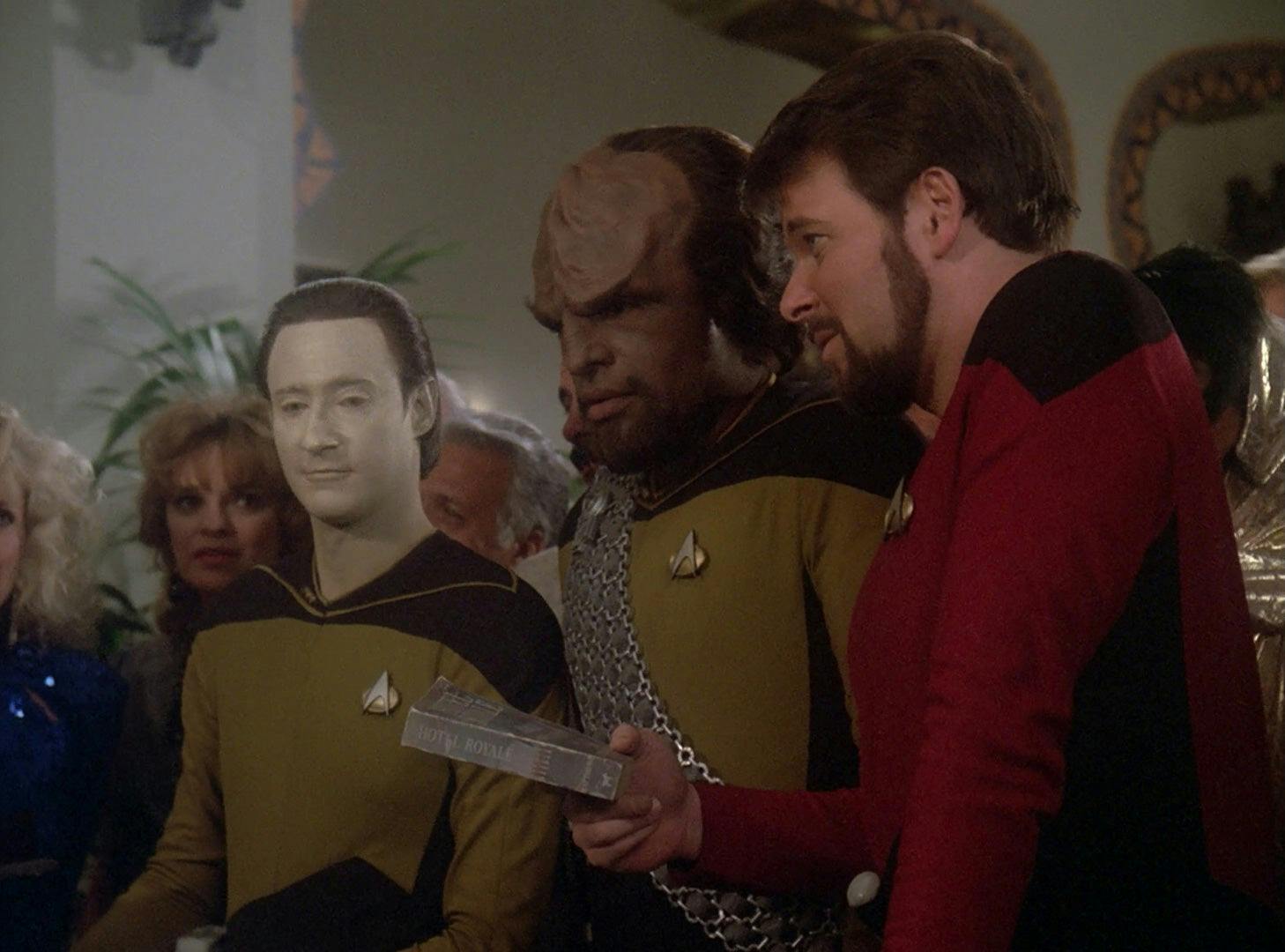 Data, Worf, and Riker hold a dusty copy of the book Hotel Royale.