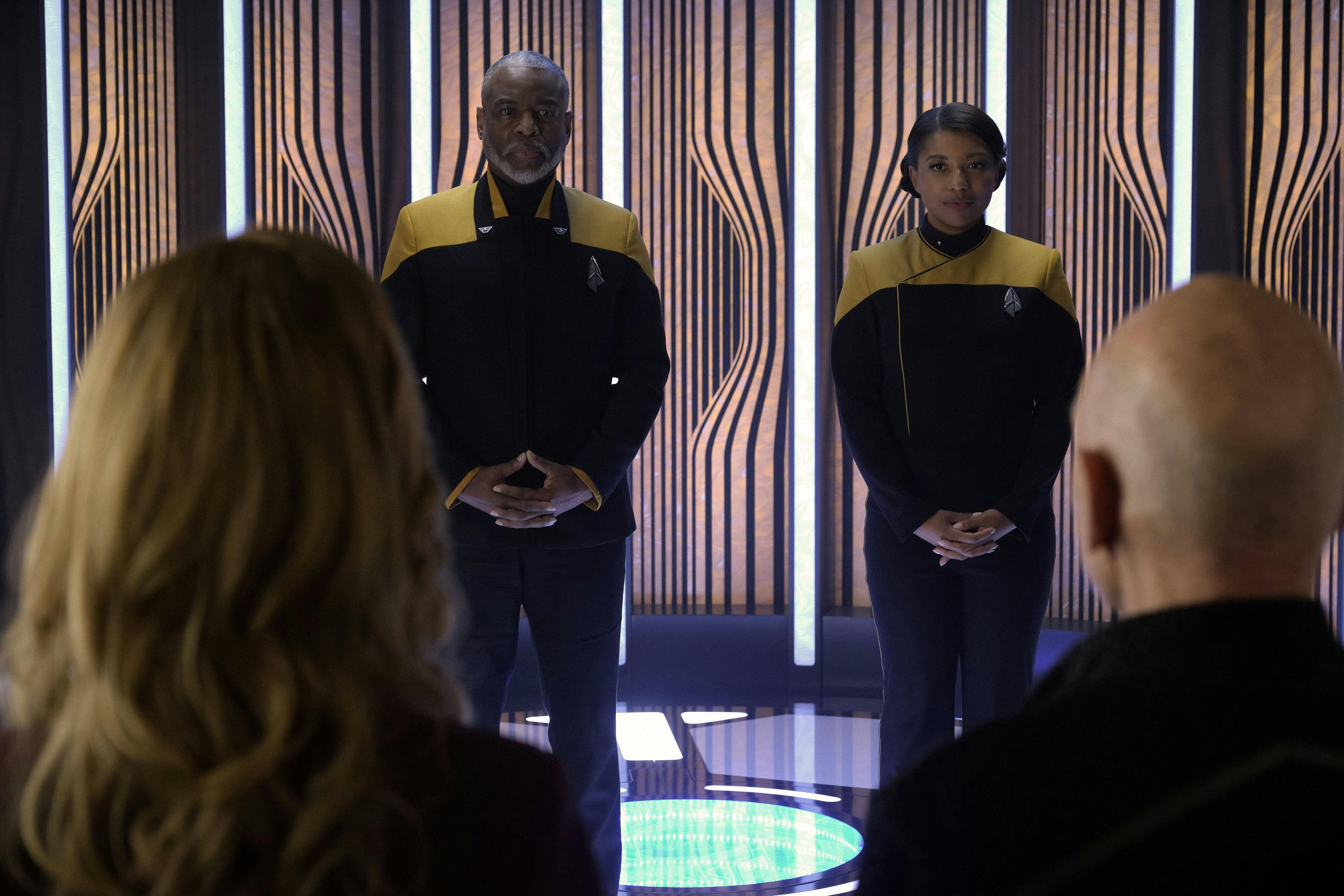 Geordi and Alandra La Forge standing on the transporter looking at Seven of Nine and Picard in front of them