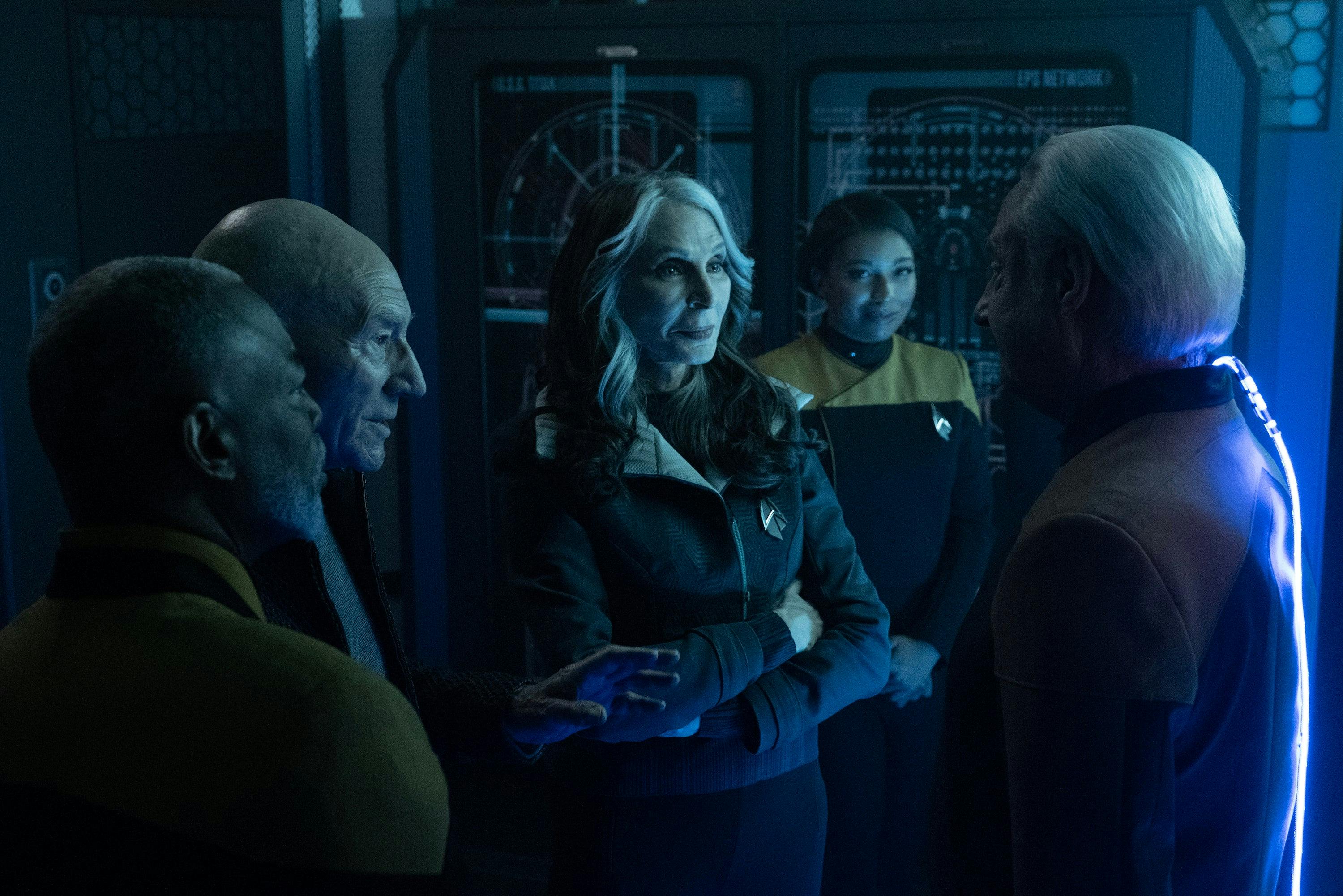 Geordi La Forge, Jean-Luc Picard, Beverly Crusher, and Alandra smile as they all face Data