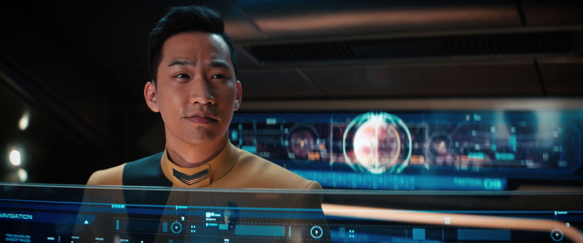 Close-up of Gen Rhys at his tactical station as he smiles and looks ahead in 'Kobayashi Maru'