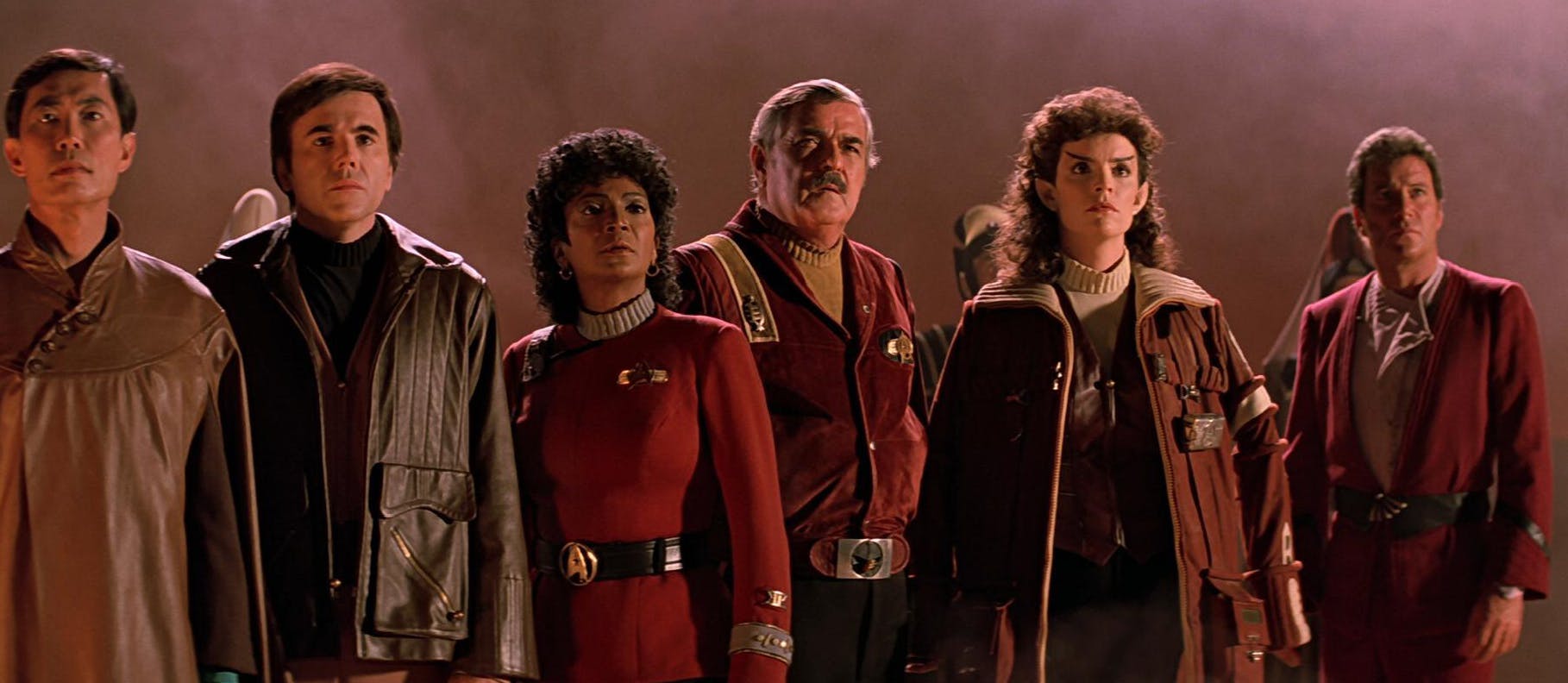 Standing in a row, Sulu, Chekov, Uhura, Chekov, Saavik, and Kirk, all look ahead of them with curiosity and intensity in Star Trek III: The Search for Spock