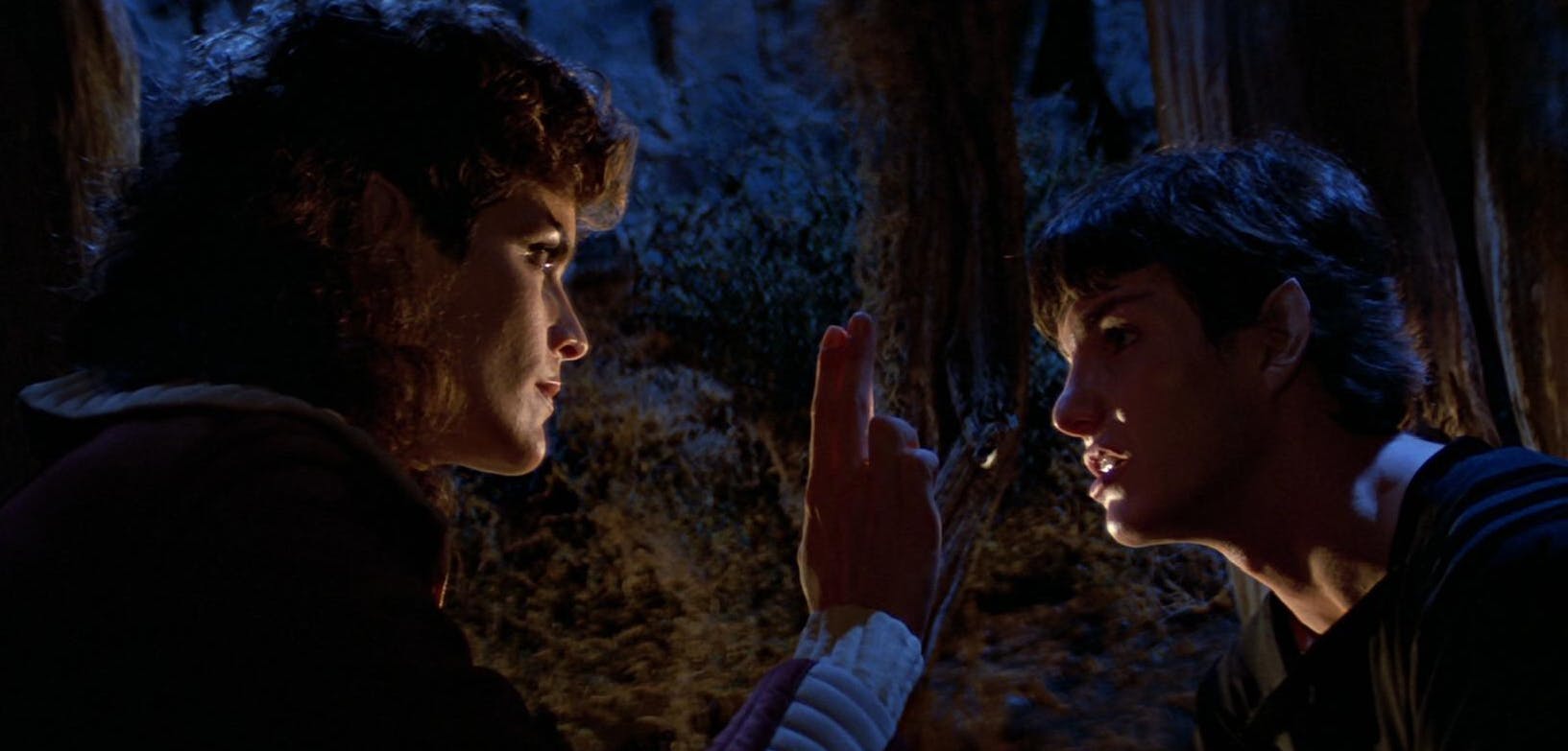 Saavik lifts up two fingers, a Vulcan gesture, as she stares directly into the eyes of a younger Spock in Star Trek III: The Search for Spock