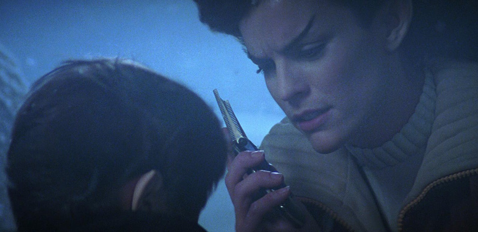 Hovering over a younger Spock, Saavik lifts her communicator to her face in Star Trek III: The Search for Spock
