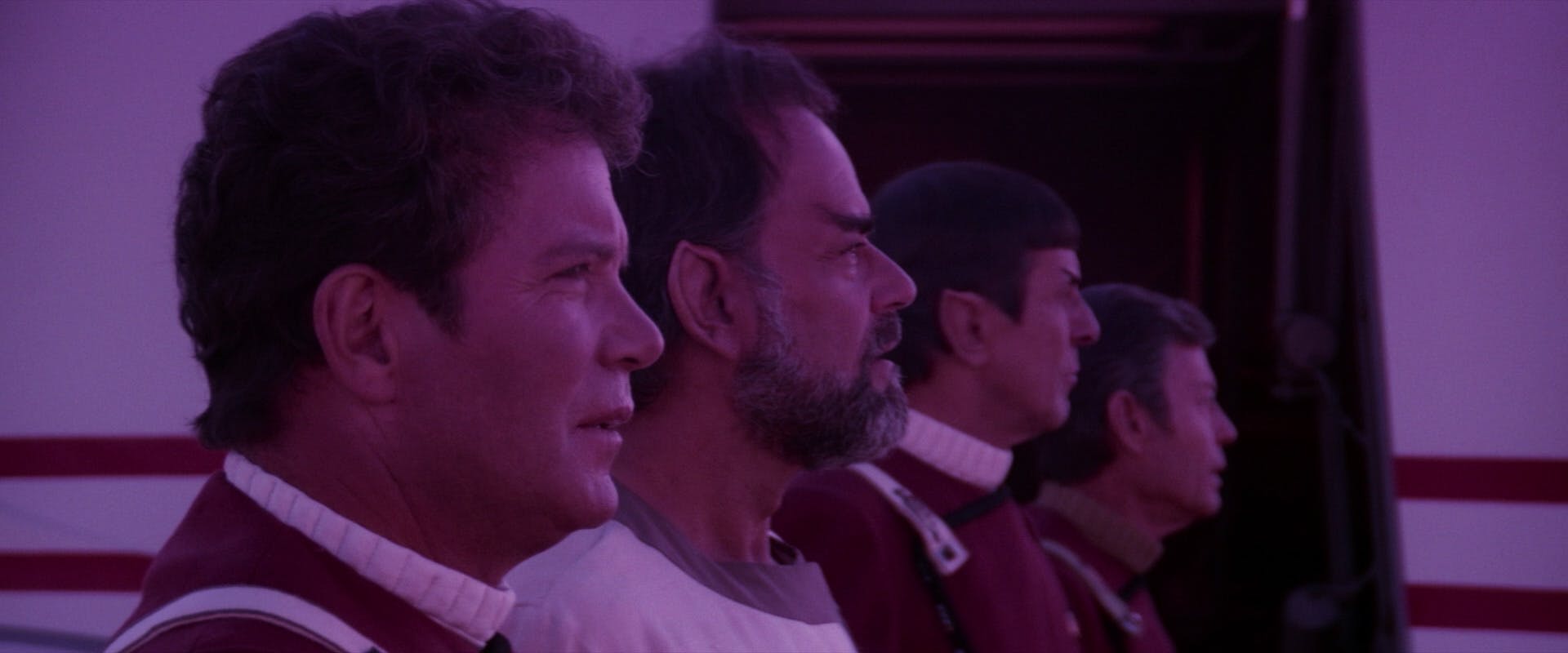 Standing in a line, Kirk, Sybok, Spock, and McCoy all stare out in the distance in front of them in Star Trek V: The Final Frontier