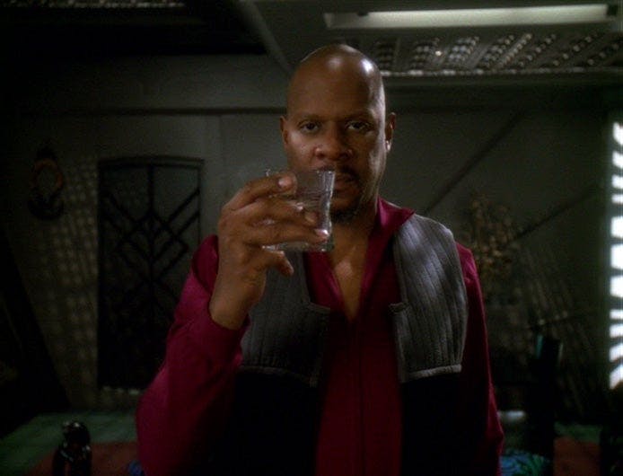 Sisko raises his glass while dictating his personal log in his room on Star Trek: Deep Space Nine