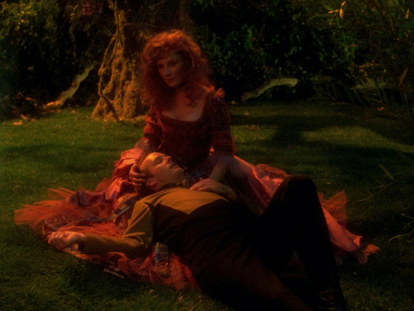 Barclay in his Starfleet uniform lies down in the lap of a simulation Beverly Crusher on the Holodeck