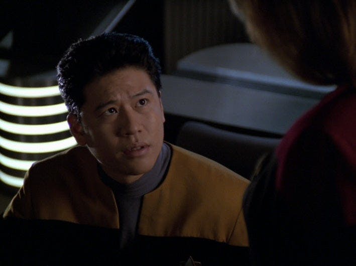 Ensign Kim looks up at Captain Janeway.
