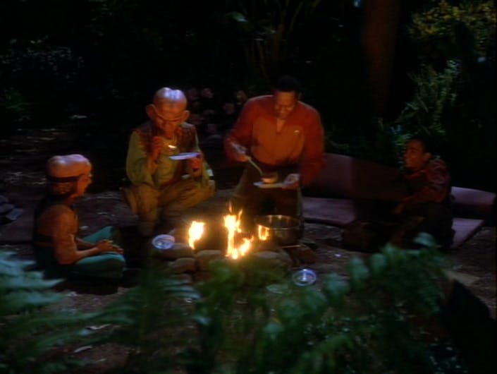 On a camping trip in the Gamma Quadrant on a M-class planet, Sisko, Jake, Nog, and Quark huddle around a campfire at night eating a meal in 'The Jem'Hadar'