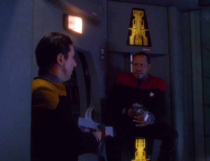 Captain Sisko sits outside of a Jefferies tube in 'The Adversary'