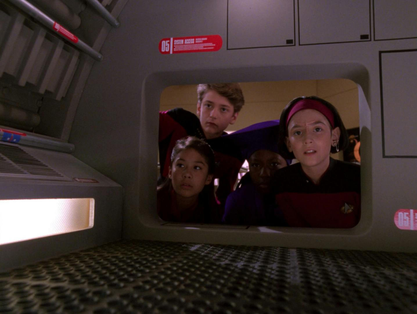 Young versions of Picard, Keiko, Guinan, and Ro Laren prepare to reclaim the Enterprise-D from marauders as they peer into a Jefferies tube in 'Rascals'