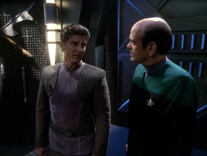 The Bajoran Iden looks over his shoulder towards The Doctor on a ship full of holograms in 'Flesh and Blood'