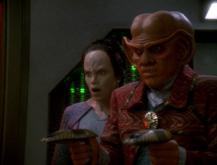 Quark holds two armed phasers as Tora Ziyal expresses shock beside him in 'Sacrifice of Angels' 